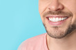 © New Africa - Smiling man with perfect teeth on color background, closeup. Space for text