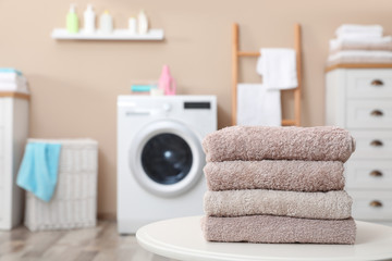 Canvas Print - Stack of towels on table against blurred background, space for text