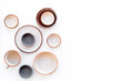 © 9dreamstudio - Ceramic tableware pattern. Empty plates and mugs on white background top view copy space
