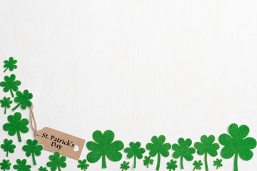 Wall Mural - St Patrick's Day, March 17, with green clover leaf, green water and paper tag on white wooden background