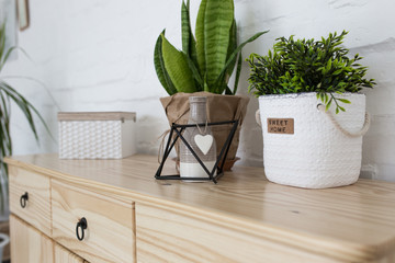 Interior living room with a wooden chest on a white brick wall