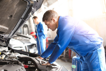 Wall Mural - Male mechanic fixing car in service center