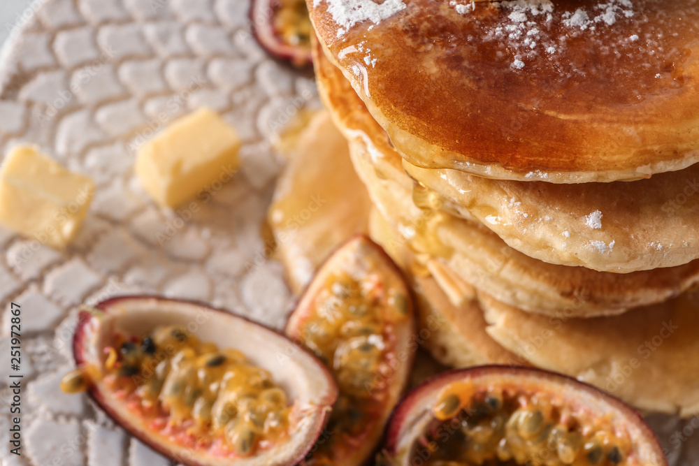 Tasty pancakes with passion fruit and butter on plate, closeup