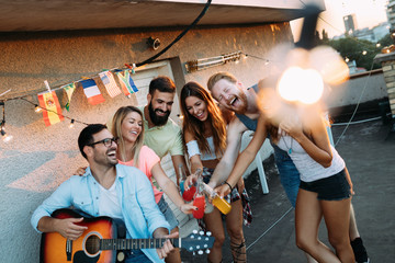 Wall Mural - Group of happy friends having party on rooftop