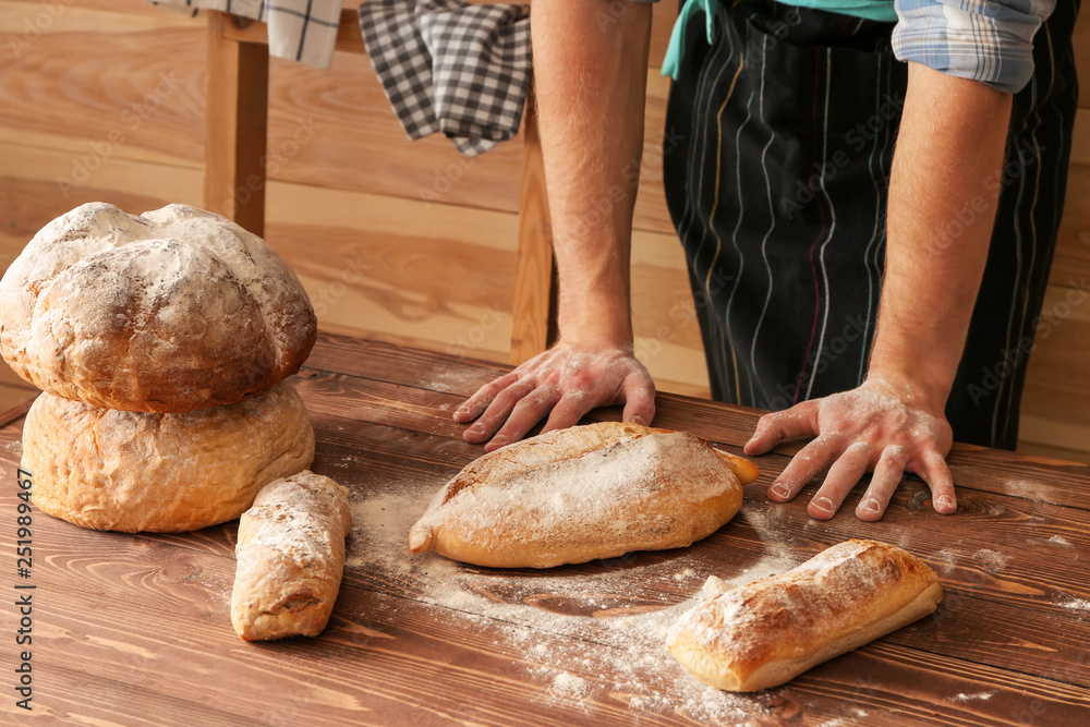 Man with freshly baked bread on table