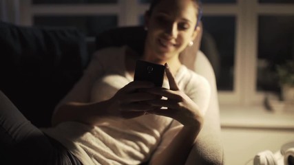 Wall Mural - Happy girl chatting late at night with her smartphone