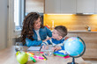 © Dragana Gordic - Cute boy with mother doing homework at home.