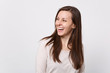 © ViDi Studio - Portrait of laughing joyful attractive young woman in light clothes standing, looking aside isolated on white wall background in studio. People sincere emotions lifestyle concept. Mock up copy space.