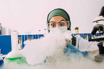 Wall Mural - shocked female muslim scientist experimenting with dry ice in laboratory