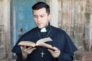 Cute priest studying the Bible 