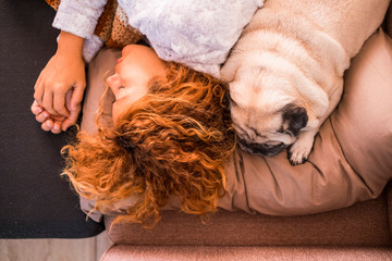 Love and protection and best friends forever concept with beautiful caucasian woman sleeping near her lovely puppy dog pug - friendship from top vertical view