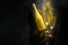 Romantic Picture Of Golden Champagne Bottle, Two Wine Glasses On Black Stone Background