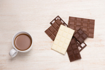 A lot of variety chocolates bar in box on white wooden background