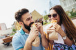 Young couple is eating sandwiches and having a great time