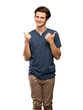 © luismolinero - Teenager man giving a thumbs up gesture and smiling over isolated white background