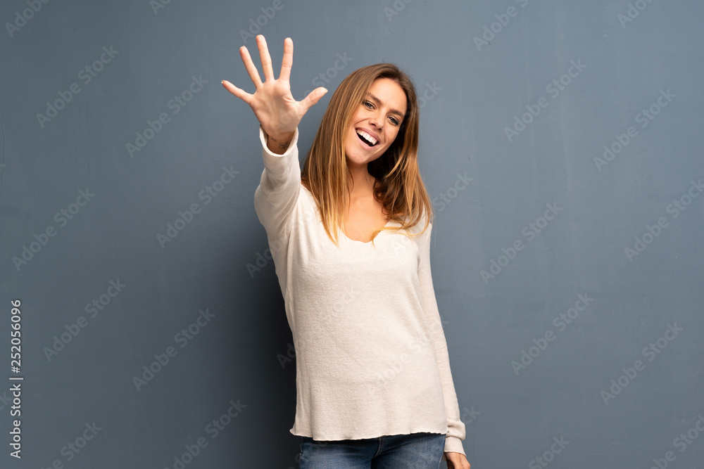 Blonde woman over grey background counting five with fingers - obrazy, fototapety, plakaty 