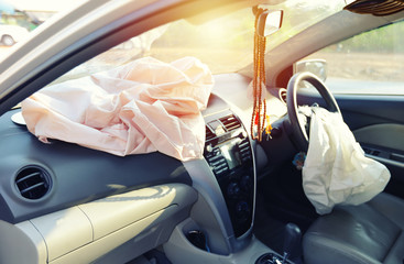 Airbag exploded at a car accident with sunlight on windshield