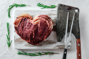 Wall Mural - Heart shape marbling ribeye steak on white plate. Prime rib beef chop