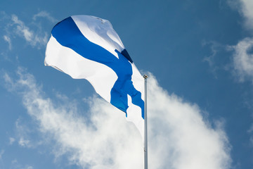 Wall Mural - National flag of Finland on pole at wind on blue sky and clouds background.