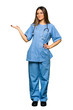 © luismolinero - Full body of Young nurse holding copyspace imaginary on the palm to insert an ad
