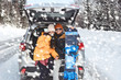 © Galina_lya - Young couple is sitting in the back trunk of suv car on roadside of winter road and drinking hot tea from thermos. Family trip to ski resort. Winter holidays adventure. travelling lifestyle concept.