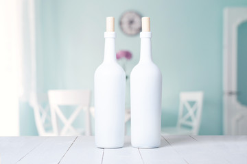 Wall Mural - Red wine bottle on a white wooden background