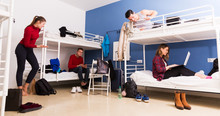 Travelers Communicating In Hostel Bedroom