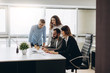 © JJ Studio - Young coworkers. Young modern colleagues in smart casual wear working while spending time in the office