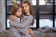 © nazarovsergey - The image of two little sisters sitting on the bed in the room.