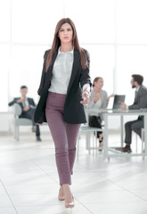 Poster - in full growth.young business woman on the background of the office