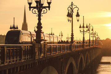 Poster - Modern city tram on Pont de Pierre bridge in Bordeaux at sunset