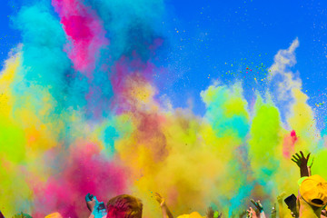 crowd throws colored powder at holi festival