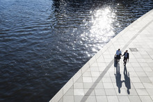 Two Businessmen Walking And Talking At The Riverbank