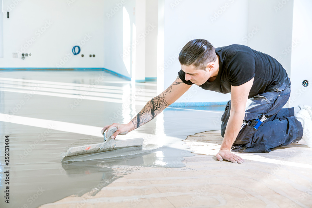 Bodenleger arbeitet mit selbstnivellierendem Zementmörtel. 