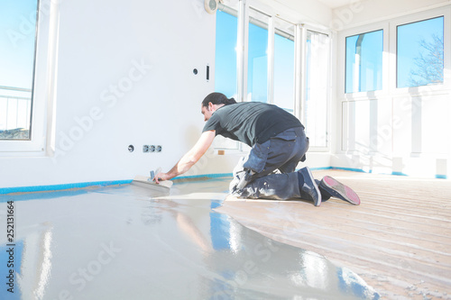 Plasterer During Floor Covering Works With Self Levelling Cement