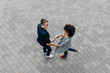 © Westend61 - Top view of two colleagues shaking hands on a square