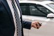 Businessman using remote control key of car, partial view