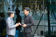 © DragonImages - Business people talking outdoors