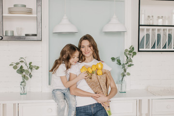 little girl gives flowers to mother on march 8