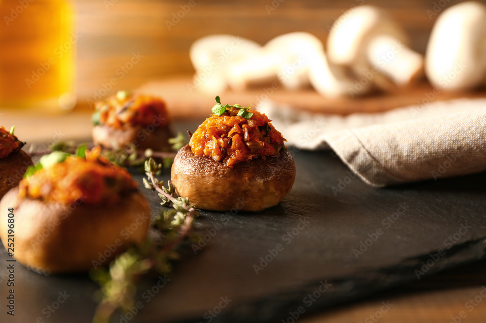 Tasty stuffed mushrooms on slate plate