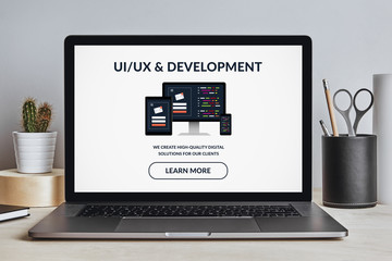 Wall Mural - ui/ux design and development concept on laptop screen on modern desk