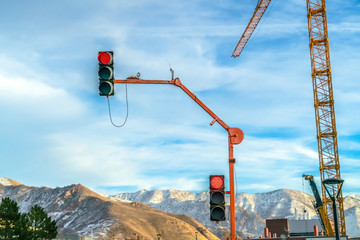 Traffic lights and crane against mountain and sky