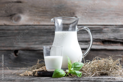 Fotomural Fresh milk in glasses in front of a rustic vintage background
