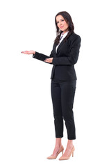 Happy confident business woman in black suit invite to join business meeting. Full body isolated on white background. 