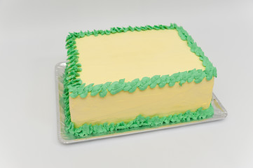 Birthday cake with green and yellow colors. Isolated on white background. Horizontal image. Side view.