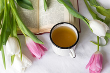 Mug Of Tea, Pink , White  Tulips, Book On White Sheets, Top View
