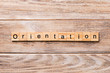 Orientation word written on wood block. Orientation text on wooden table for your desing, concept
