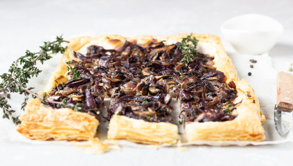 Mushroom tart, puff pastry pie with cream cheese, mushrooms, onion and thyme. Light concrete background. Copy space.