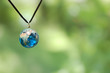 Blue Glass Earth Necklace on Green Background
