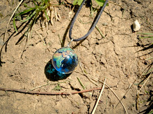 Earth Globe Necklace On Dry Cracked Ground
